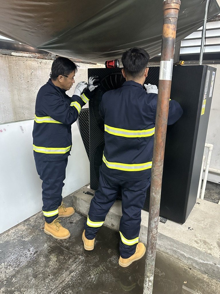 Two Karnot engineers in uniform commissioning an iHEAT heat pump on site